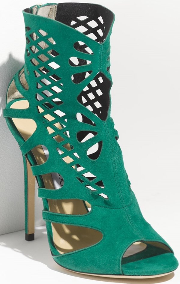 Elegant cutouts cage the foot in delicate geometry, realized in emerald green suede