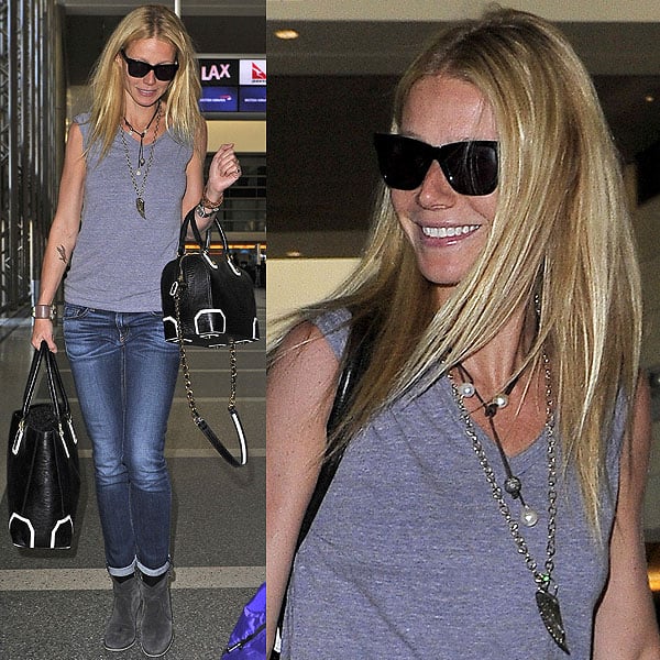 Gwyneth Paltrow dresses up a simple t-shirt and jeans ensemble with a cute gold angel wing necklace, elegant matching handbags, and comfy gray suede ankle boots