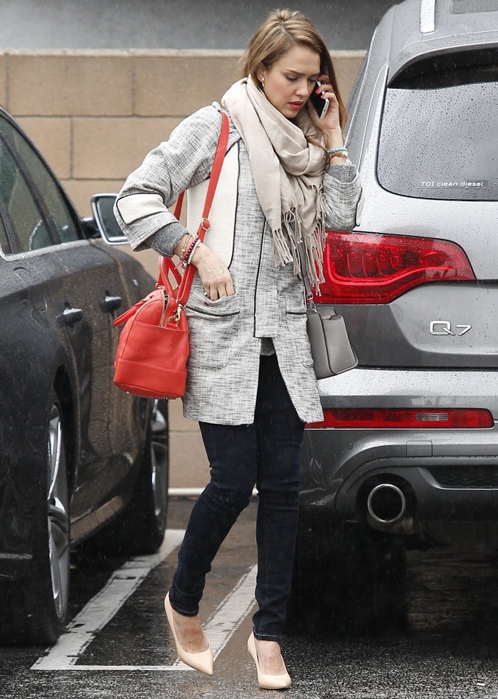 Jessica Alba paired her heels with dark denim skinnies, a textured coat by H&M, a cozy wrap scarf, and a bright red Tory Burch satchel bag