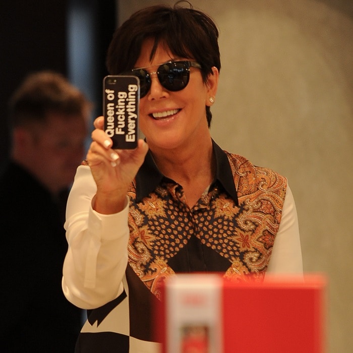 Kris Jenner showing off her iPhone case that reads 'Queen Of F**king Everything'