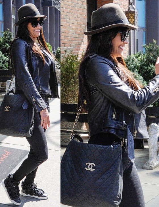 Paula Patton wearing a black leather jacket over an all-black outfit, a quilted Chanel purse, plus a black hat