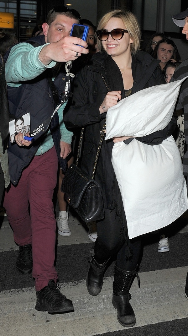 Demi Lovato greeting fans as she arrives at Heathrow Airport in London