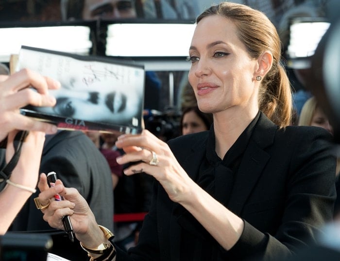 Angelina Jolie signing autographs as she arrives for the premiere of 'World War Z'