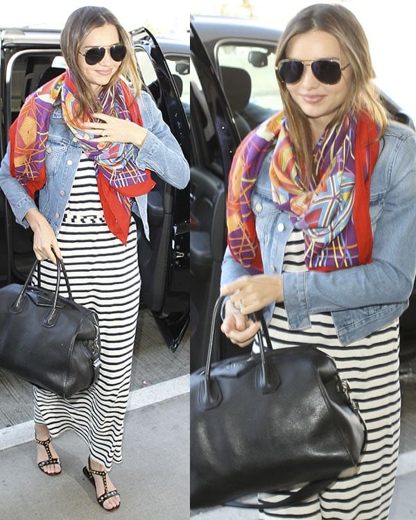 Miranda Kerr arrives at LAX airport a striped maxi dress, a cropped denim jacket, a colorful scarf, and a pair of studded black sandal flats