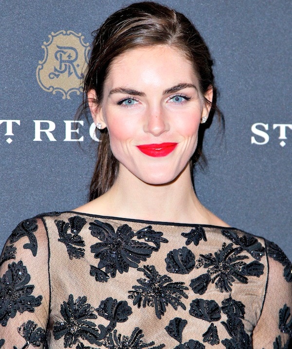 Hilary Rhoda's hair was styled in a messy ponytail, which showed off her stunning blue eyes, bright red lips, and beautiful earrings