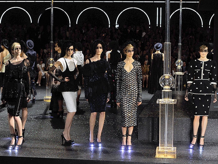 Models' LED-tipped shoes lighting up like flashlights at the Chanel Fall 2011 fashion presentation