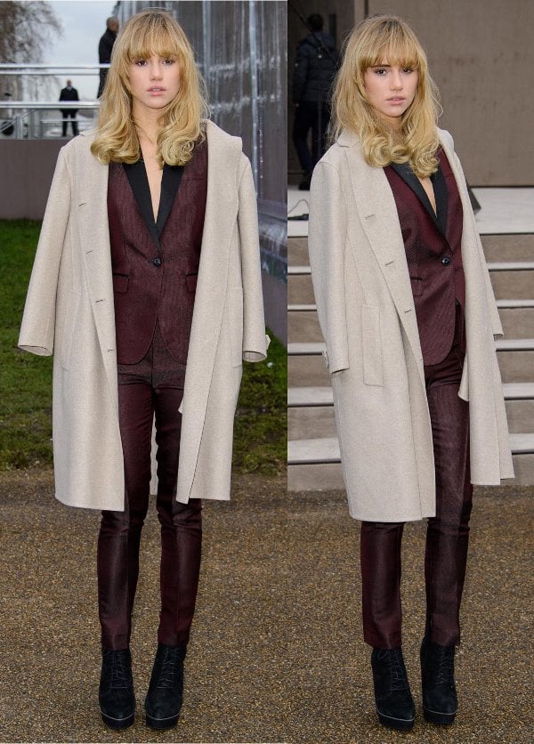 Suki Waterhouse took style inspiration from the boys by wearing a tailored satin burgundy suit with a cream wool coat