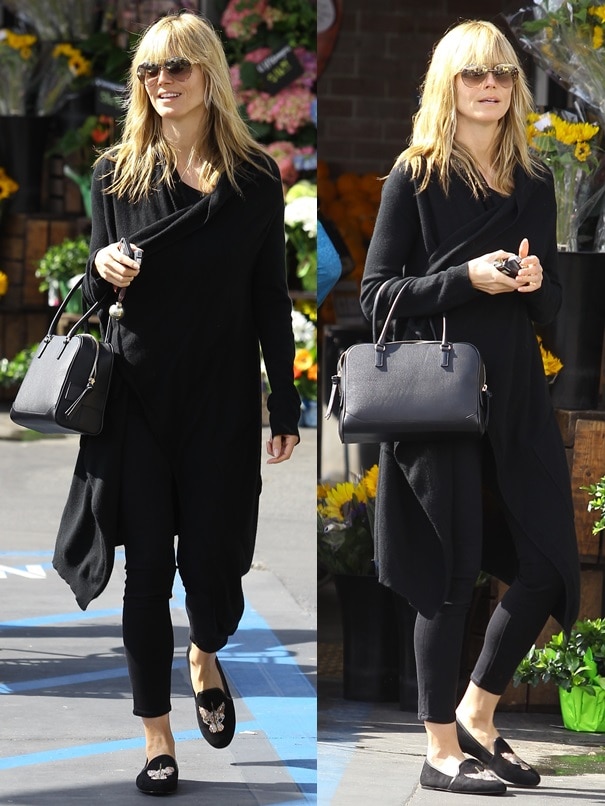 Heidi Klum went makeup-free and slipped into a long black drapey coat over some black cropped skinnies