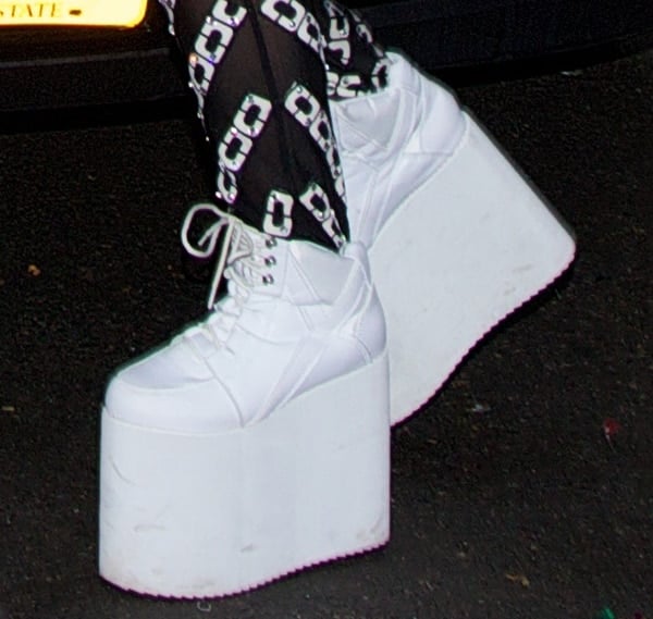 Lady Gaga wearing white lace-up sneakers with towering platforms