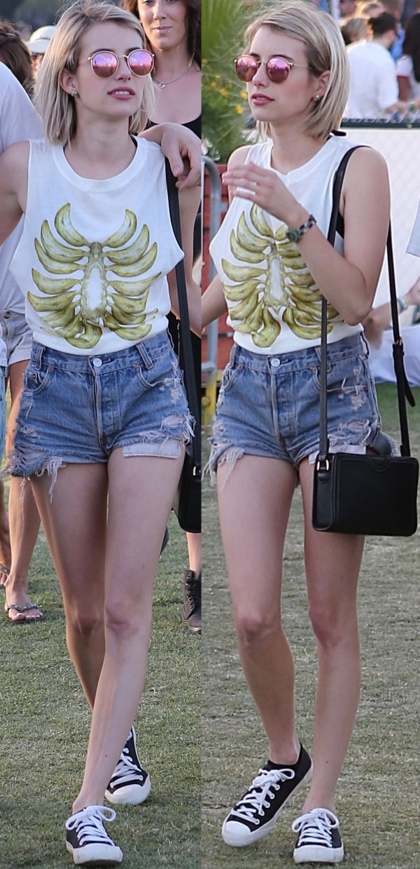 Emma Roberts in white sleeveless top tucked into a pair of distressed denim shorts