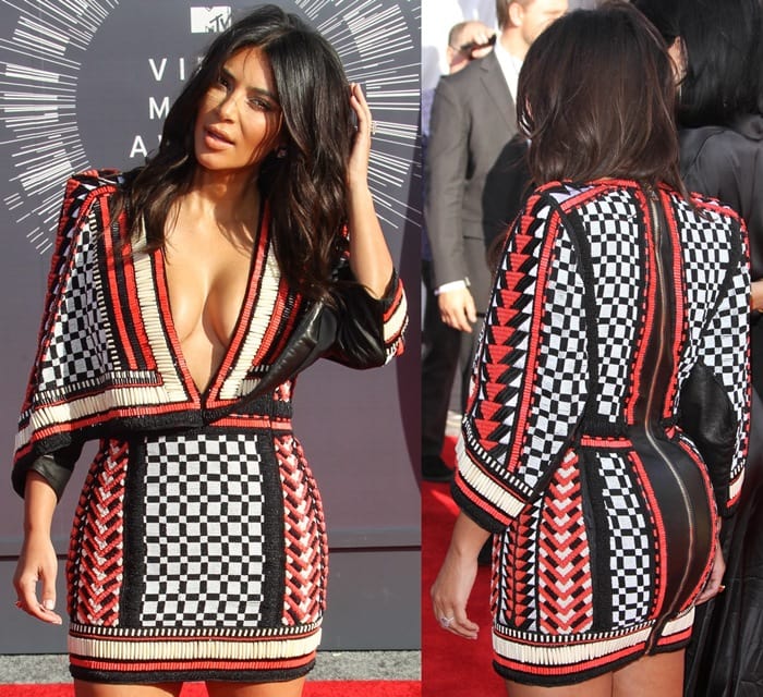 Kim Kardashian flaunted her cleavage in a heavily beaded plunging mini dress from the Balmain Resort 2015 collection featuring a cape-like shape