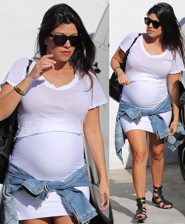 Kourtney Kardashian displayed her baby bump in a mini white dress layered with a cropped white tee for a little modesty