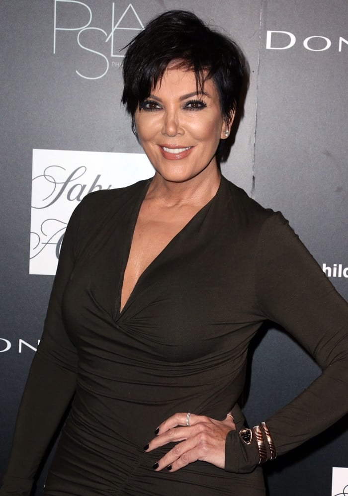 Kris Jenner in a figure-skimming dress detailed with a low-cut neckline