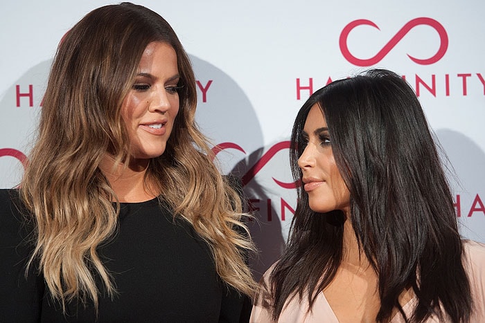 Sisters Khloe and Kim Kardashian modeling their Hairfinity Hair Vitamins–infused tresses