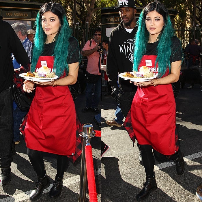 Kylie Jenner holding a Thanksgiving meal plate while wearing Balenciaga biker boots