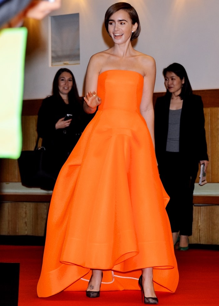 Lily Collins in a fluorescent orange mesh strapless gown from the Maticevski Resort 2015 collection