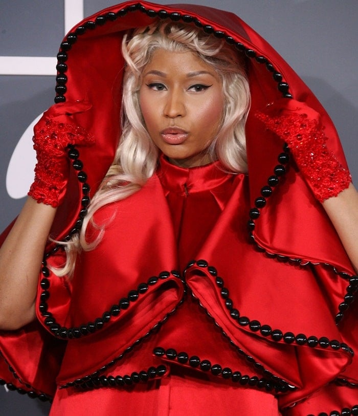 Nicki Minaj offended Catholics in a red cloak-cape outfit by Versace while accompanied by an old guy dressed as the Pope