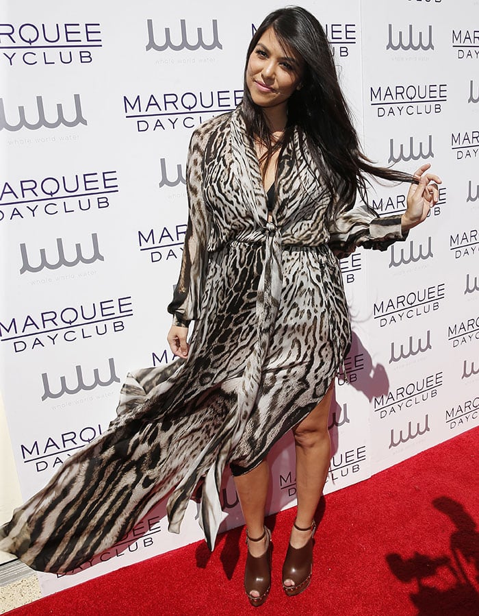 Proving that she’s the best-dressed Kardashian, Kourtney arrived at the luxury resort casino and hotel in a floor-length Roberto Cavalli leopard-print chiffon wrap dress, which gave us a peek at her black halter bikini underneath