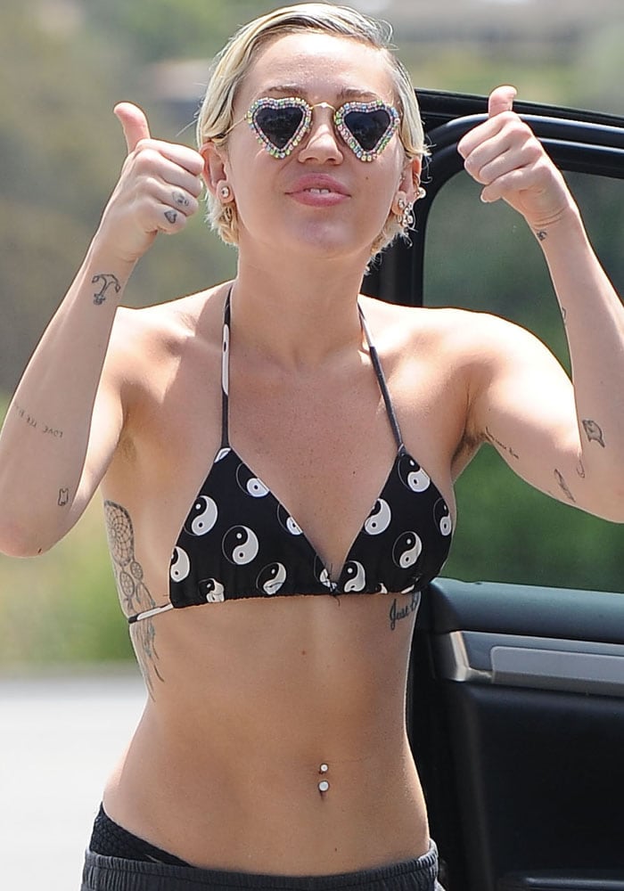 Miley Cyrus showing an unsightly forest-thick chaos going on in her armpits