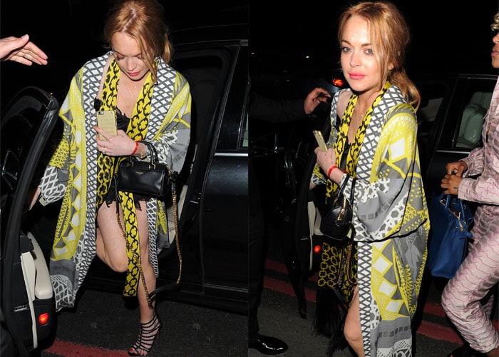 Lindsay Lohan Alaïa stopped by the Moschino party in a teeny black dress, which she wore under a bright patterned robe
