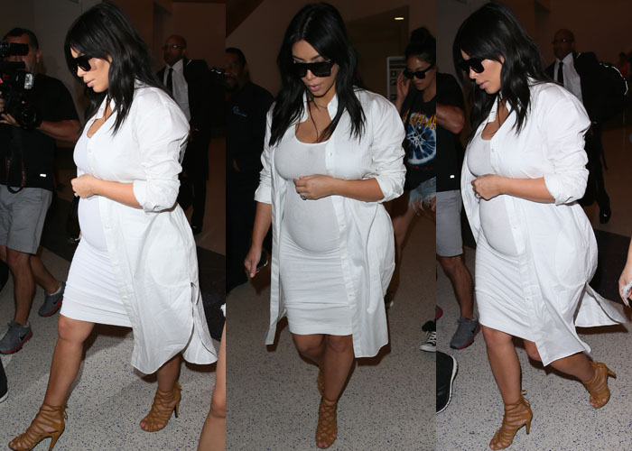 Kim wore a tight white dress around her growing pregnancy bump, which she wore under a white knee-length button-down