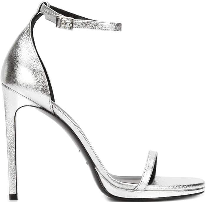 Silver Saint Laurent sandals featuring an open toe, an ankle strap with a side buckle fastening, a high stiletto heel, and a brand embossed insole