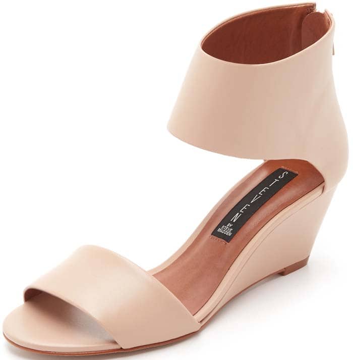 A bold ankle cuff and wrapped wedge heel amplify the contemporary sophistication of a clean, minimalist sandal in smooth leather.