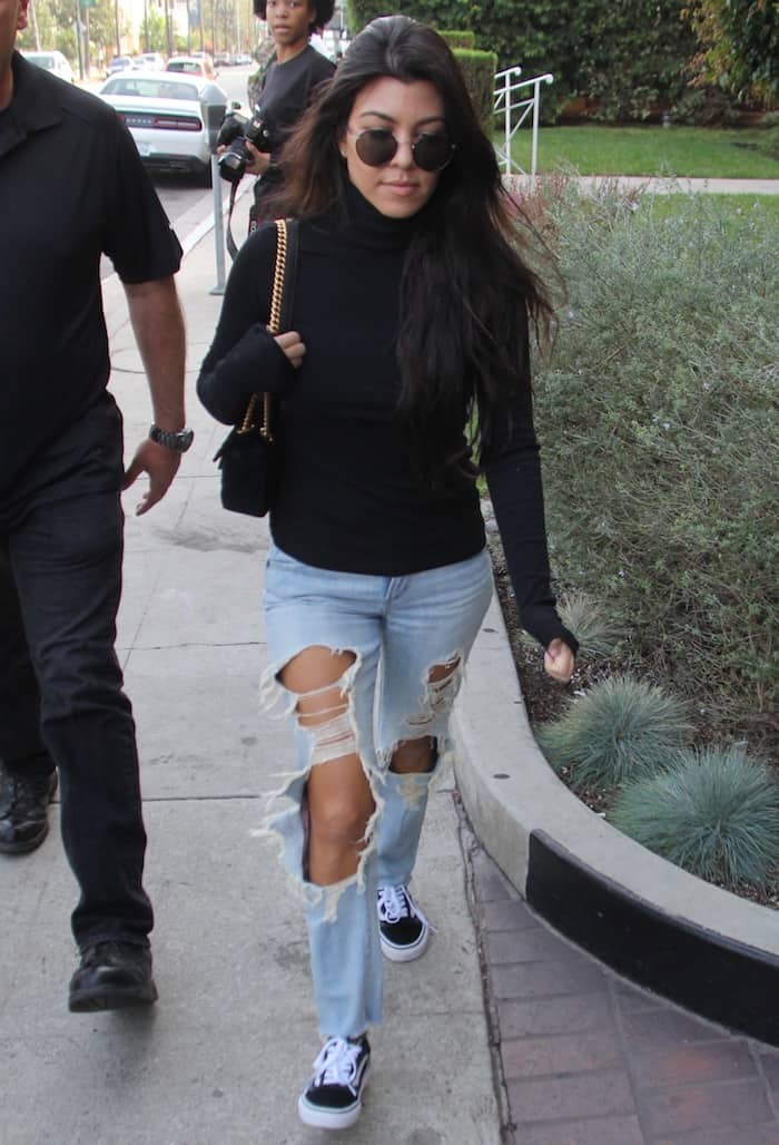 Kourtney Kardashian in distressed jeans and a black turtleneck paired with Vans 'Old Skool' sneakers while out for lunch on December 13, 2016 in Hollywood.