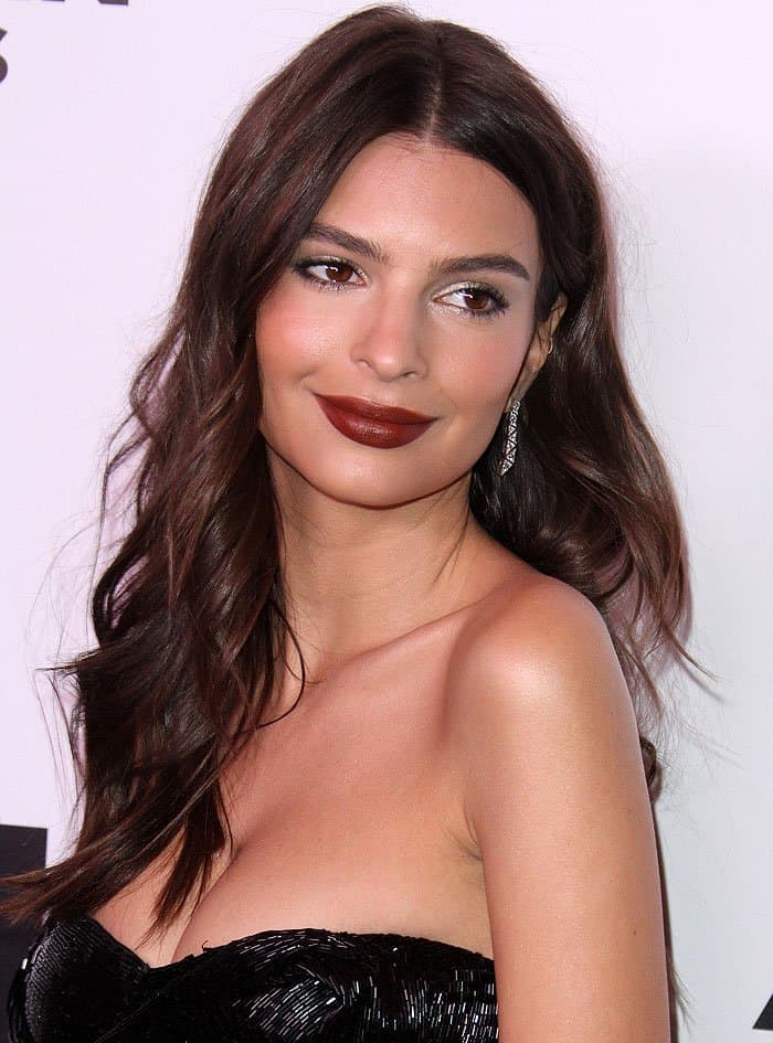 Emily Ratajkowski flaunts cleavage in a strapless dress styled with glittering earrings and deep red lipstick