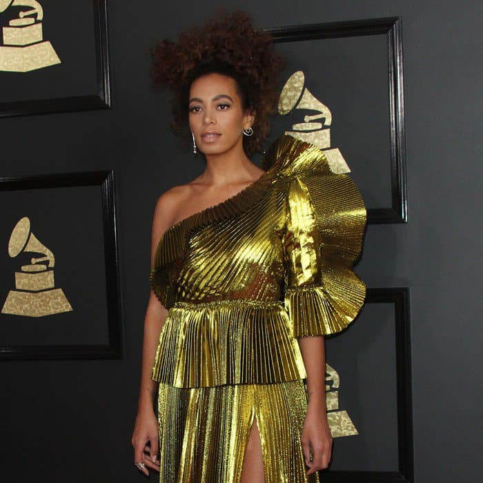Solange Knowles hit the red carpet in a one-shoulder pleated gold Gucci gown featuring a thigh-high split