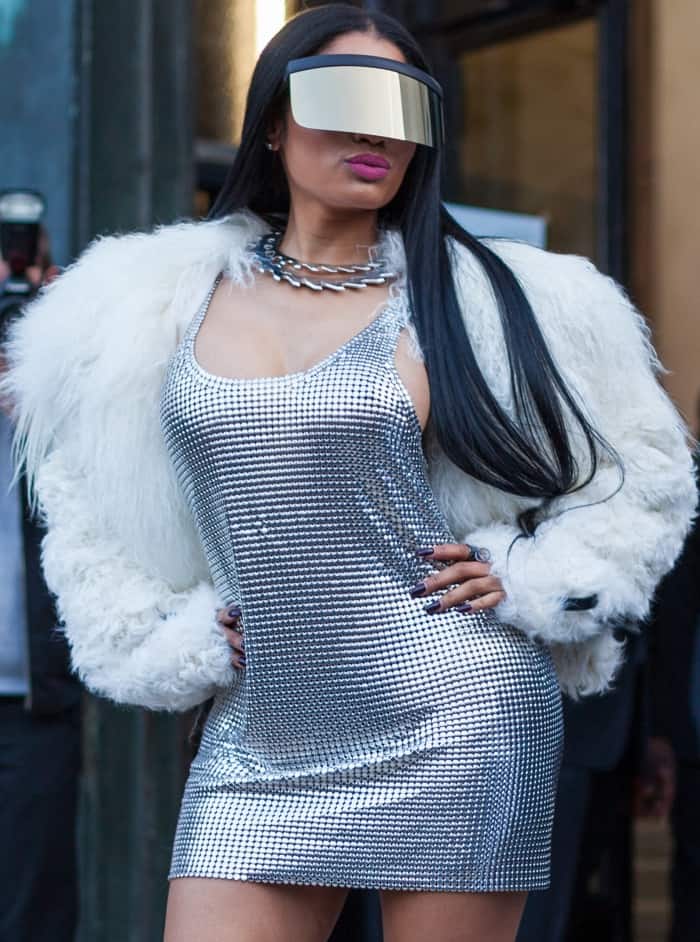 Nicki Minaj wearing a Paco Robanne chainmail dress, Monse fur coat, Mykita x Bernhard Willhelm visor, and Balmain thigh-high boots