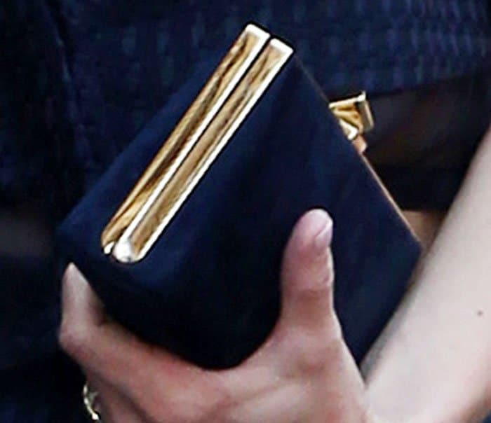 Anna holds on to a blue velvet clutch