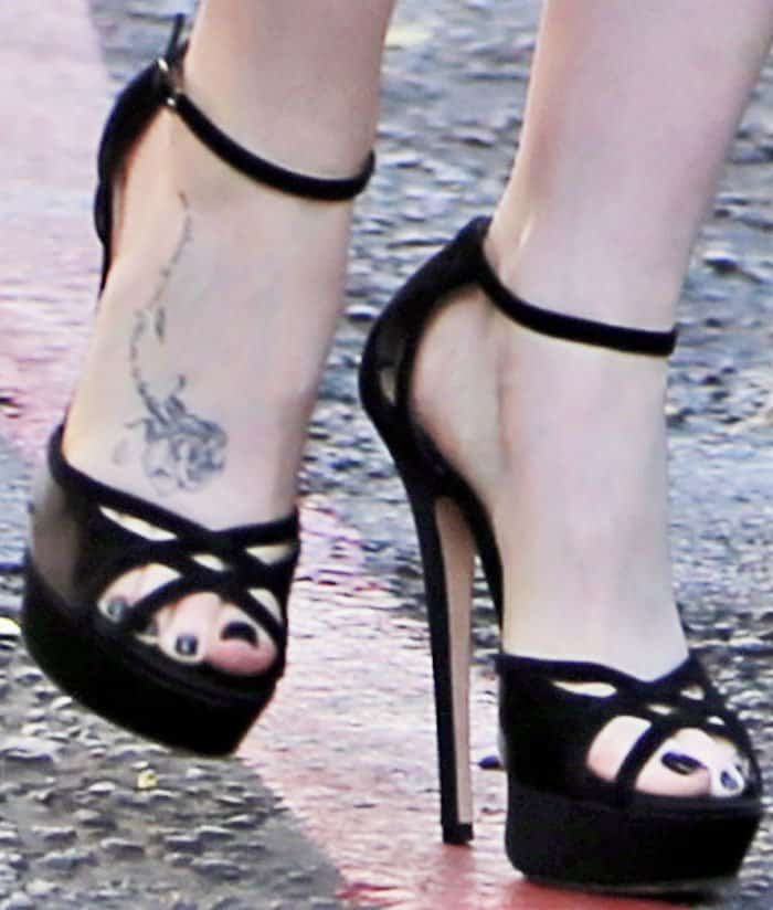 Lily wears the black version of the Jimmy Choo "Laurita" platform sandals