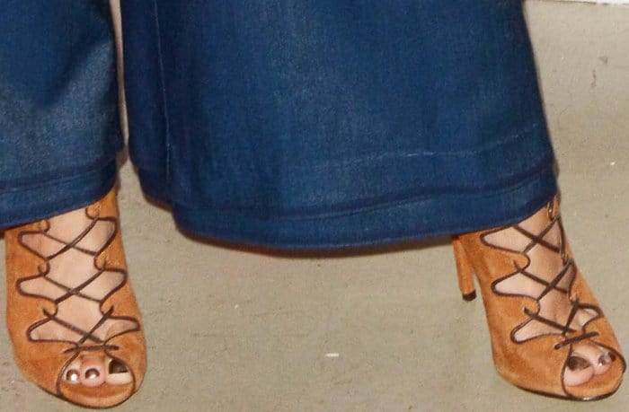 Vanessa Hudgens wearing a dark blue top, matching Manning Cartell pants, and Schutz lace-up sandals