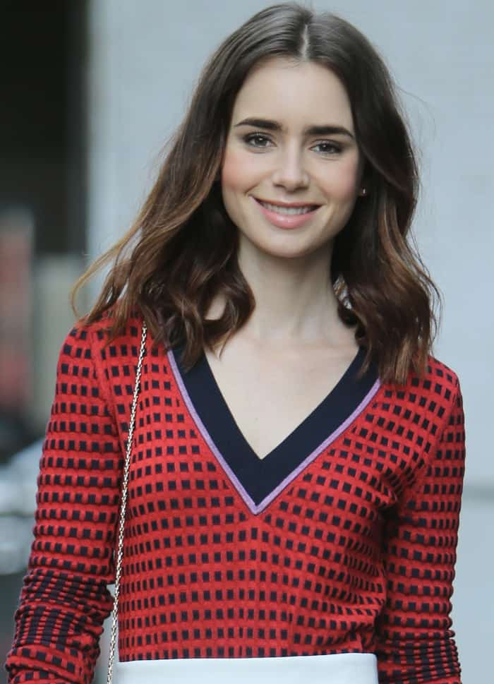 Lily Collins wearing a red patterned top, By Johnny color block skirt, and Charlotte Olympia "Dolly" pumps at the ITV studios in London