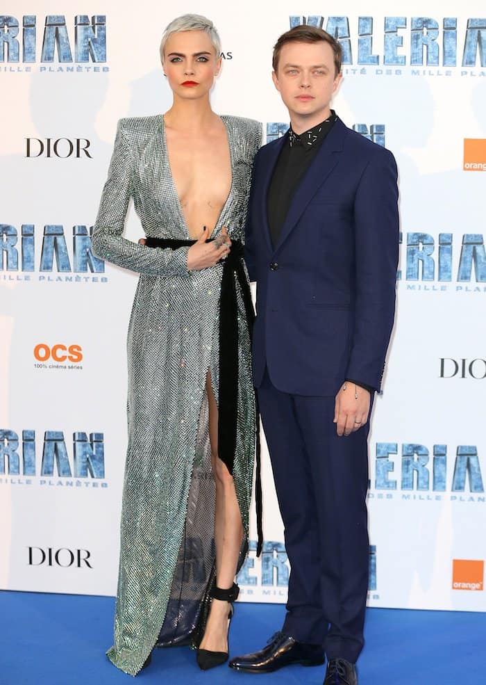 Cara Delevingne holds her dress in place alongside co-star Dane DeHaan