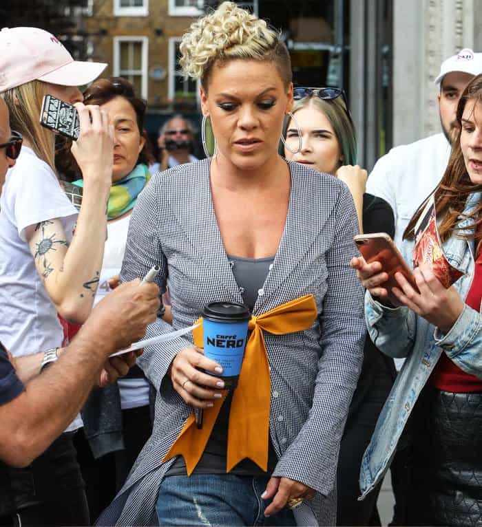 Pink walks through her throng of fans with a cup of coffee in hand