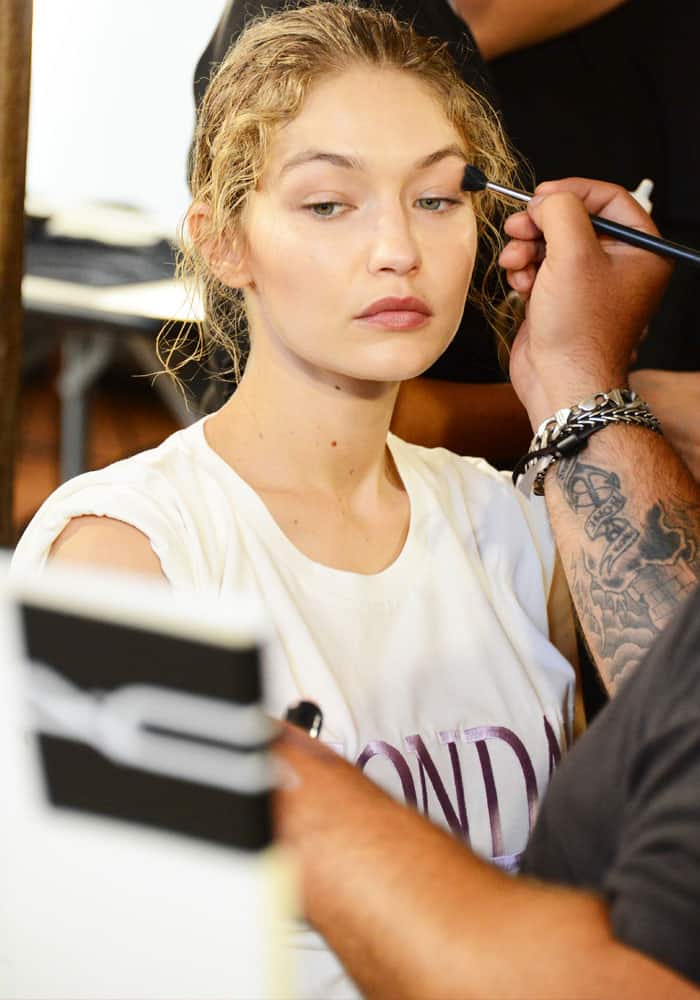 Gigi patiently sits on the makeup chair while artists create the Alberta Ferretti look