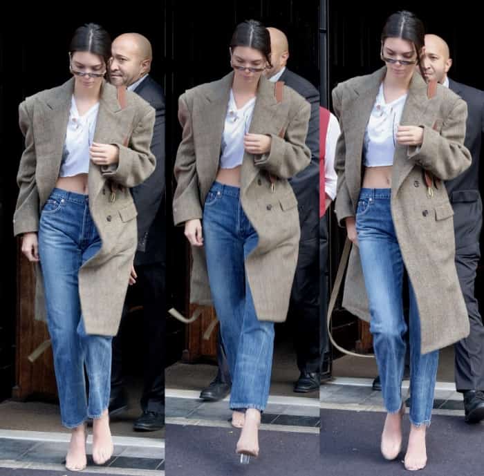 Kendall Jenner out and about NYC in jeans, a white crop top, trench coat and Yeezy Season 2 Lucite sandals.