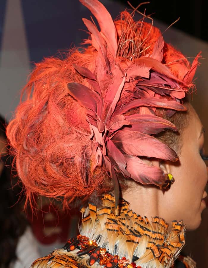 Mel B showing off her bright orange hair with feathers intertwined throughout