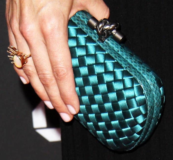 Neve inserts a little personality into her classic look with a woven turquoise clutch