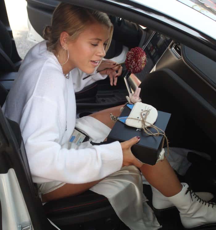 Sofia Richie wearing an all-white ensemble styled with The Row "Fara" lace-up leather combat boots 