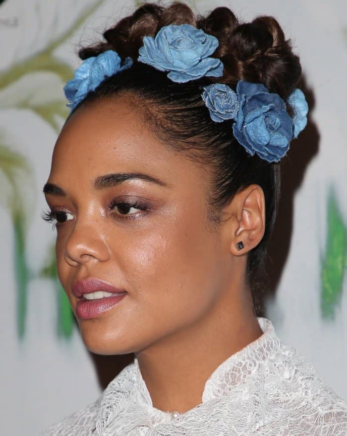 Tessa Thompson wearing a crown of blue flowers nestled on top of her braided updo at the "Woodshock" premiere