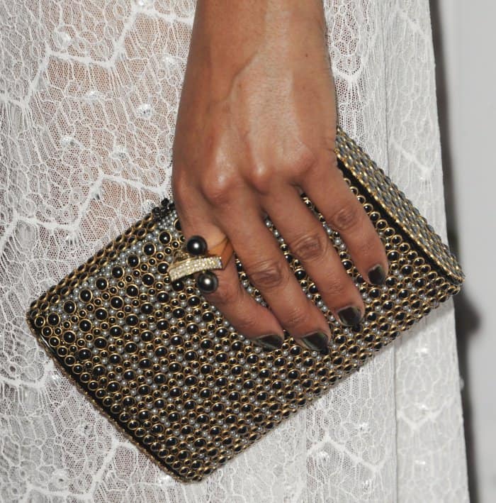 Tessa Thompson carrying an embellished black-and-gold clutch at the "Woodshock" premiere