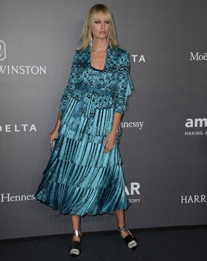 Karolina's design featured a blue-and-black patterned jacket and a fringed skirt, which she styled with tousled waves, Sharra Pagano statement earrings and an embellished clutch