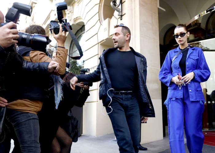 Bella Hadid wearing a blue Marques’Almeida structured jacket, matching wide-legged pants, and Off-White "For Walking" black leather pumps while leaving her hotel in Paris