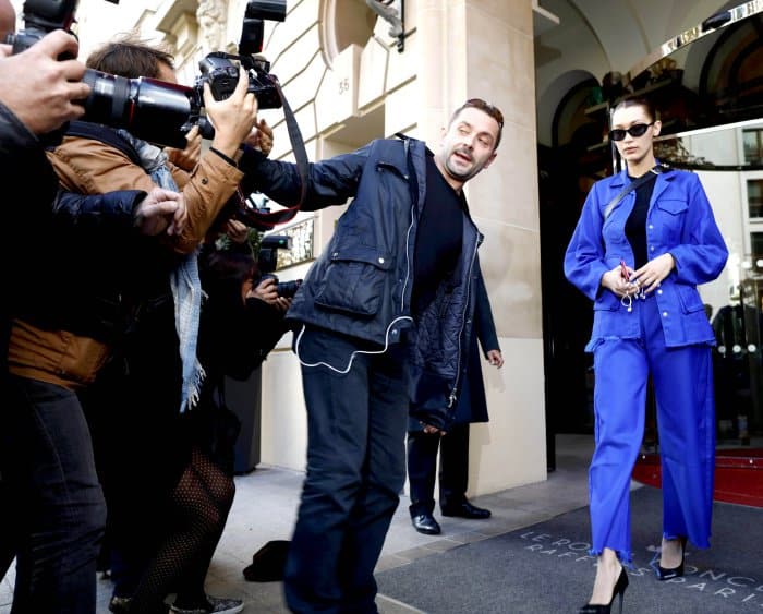 Bella Hadid wearing a blue Marques’Almeida structured jacket, matching wide-legged pants, and Off-White "For Walking" black leather pumps while leaving her hotel in Paris