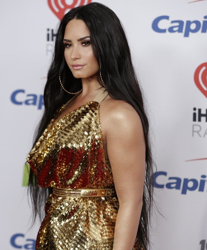 Demi Lovato's makeup by Jill Powell was golden bronze while her long dark hair was parted down the middle