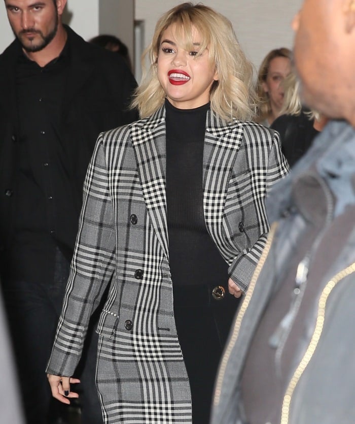 Selena Gomez wearing a double-breasted coat from Fay with tartan-print, flap pockets and upper breast pocket while arriving at the Global House in London on December 4, 2017