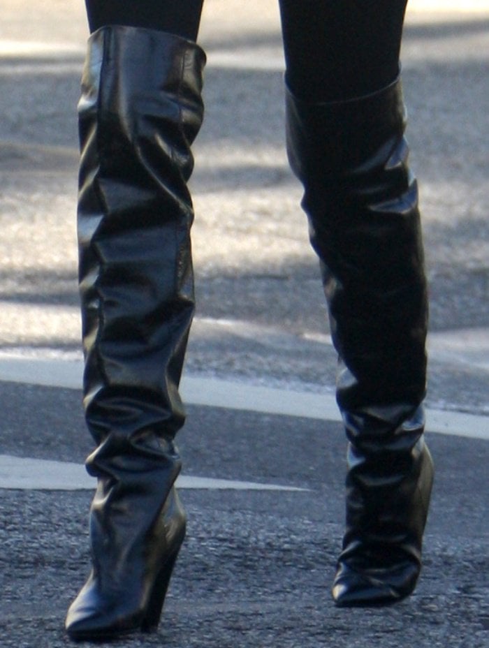 Olivia Culpo wearing Saint Laurent "Niki" glossed-leather knee boots